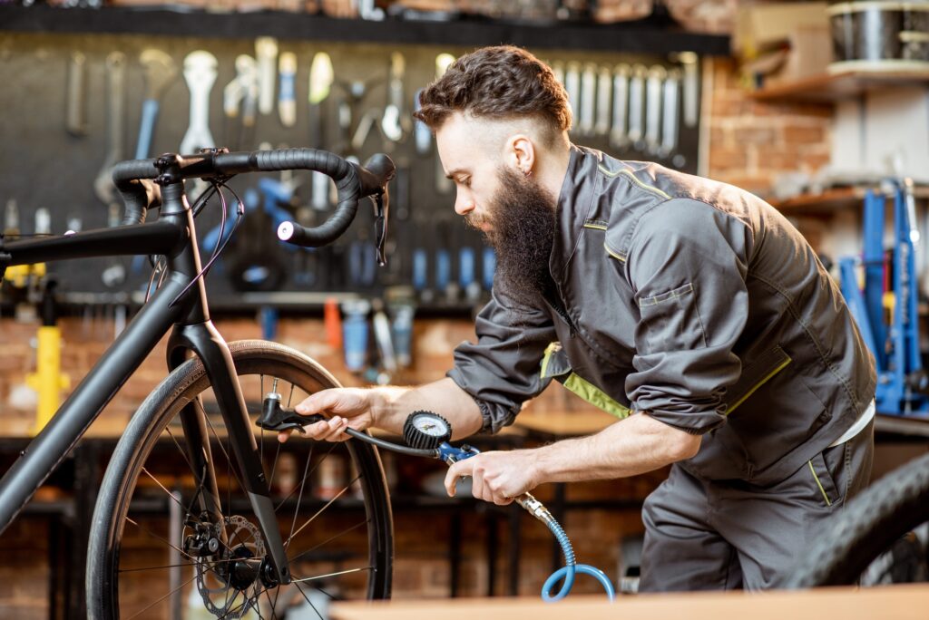 Repairman serving sports bicycle at the workshop